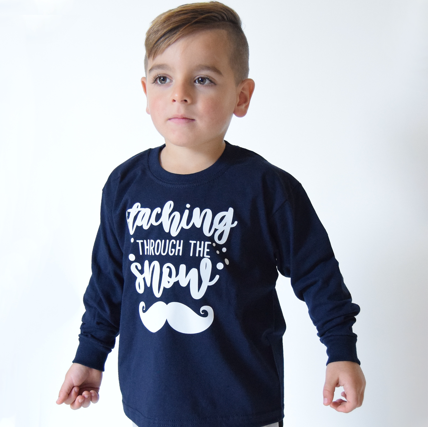 Young boy wearing navy shirt with long sleeves with 'Staching through the snow' print by KMLeon.