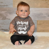 Toddler boy wearing mocha shirt, with 'Staching through the snow' print by KMLeon.