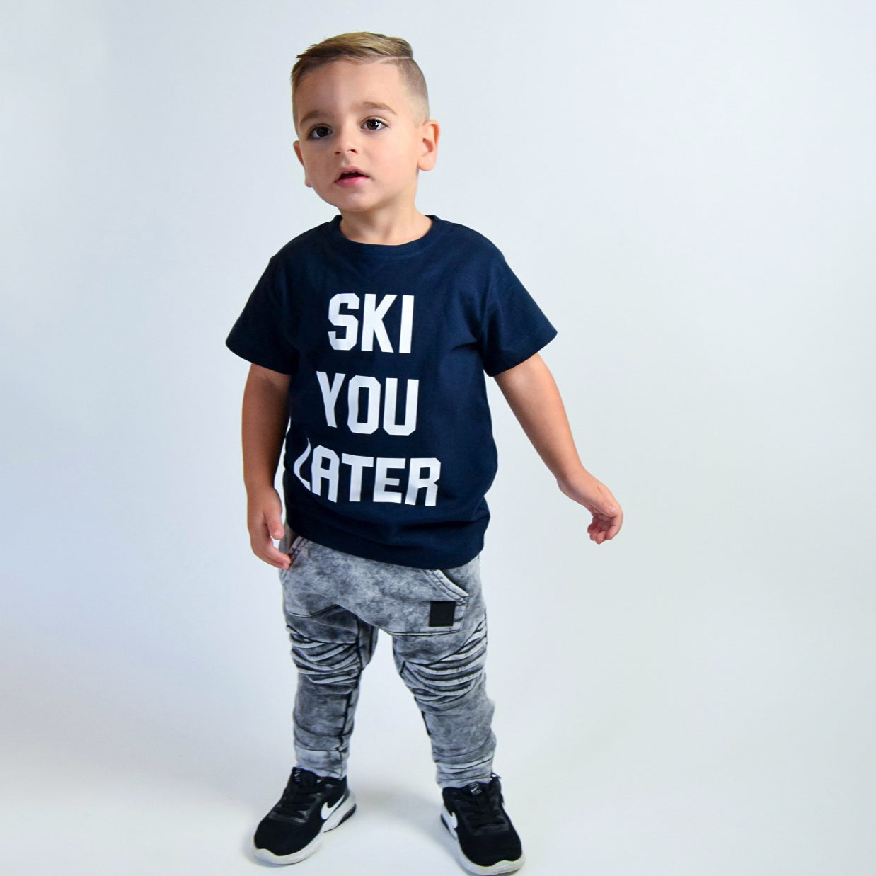 Boy wearing navy shirt with 'Ski you later' print by KMLeon.