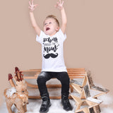 Blonde boy playing with snow, wearing white shirt with 'Staching through the snow' print by KMLeon.