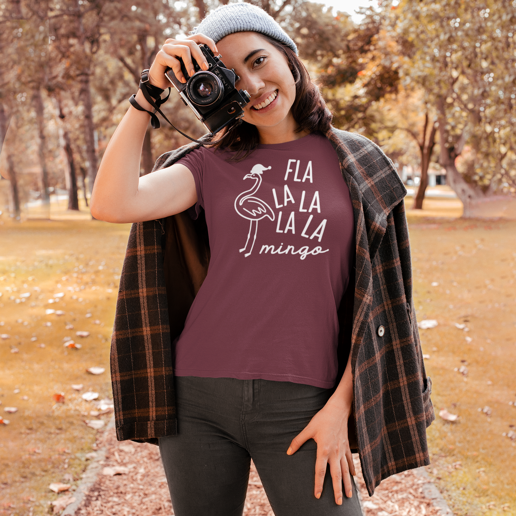 Smiling woman with burgundy shirt with 'Fla la la la la mingo' print by KMLeon, holding camera.