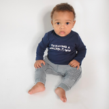 Black boy sitting wearing navy shirt with longs sleeves with 'I'm having a meltdown' print by KMLeon.