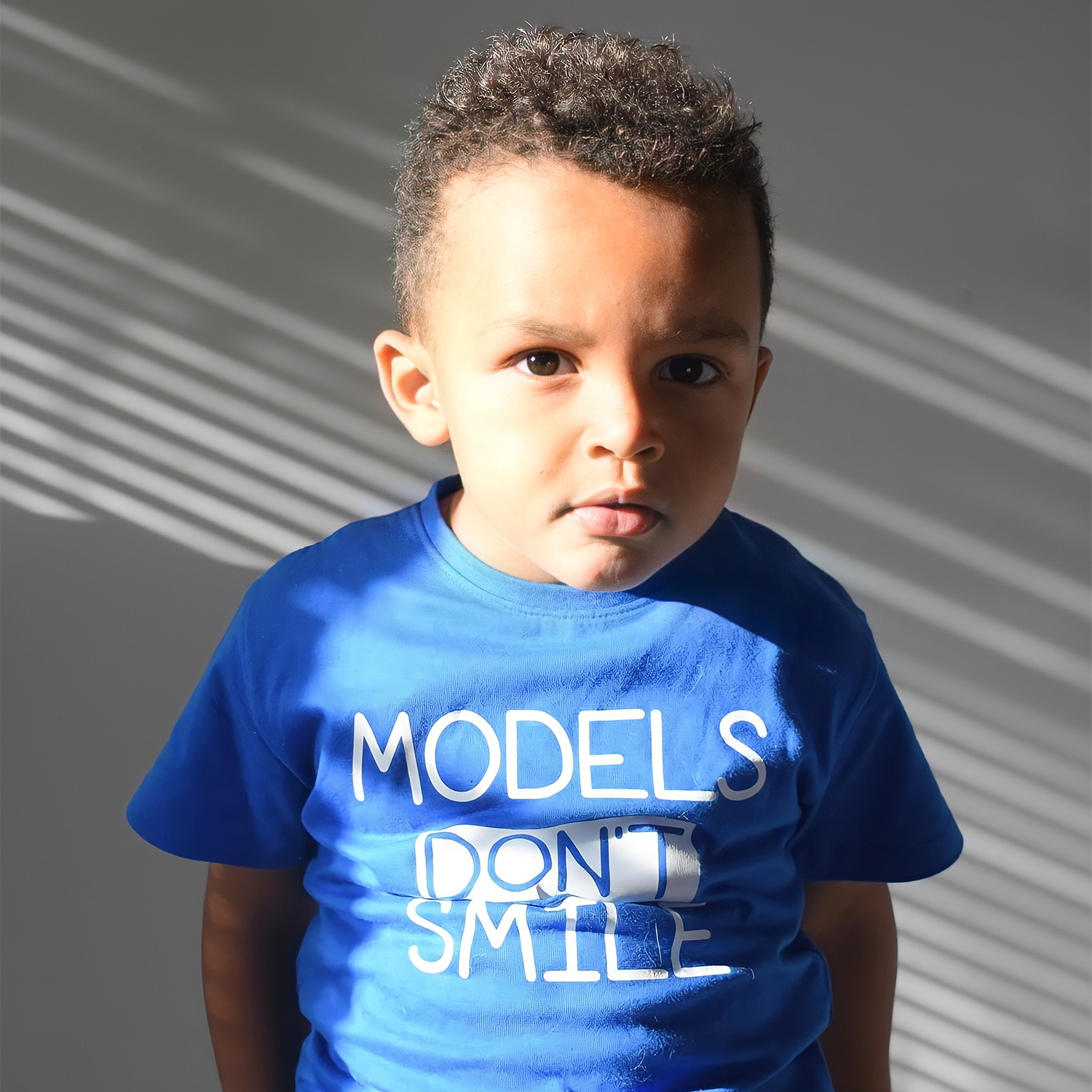 'Models don't smile' kids shortsleeve shirt