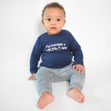 Black boy sitting wearing navy shirt with longs sleeves with 'I'm having a meltdown' print by KMLeon.