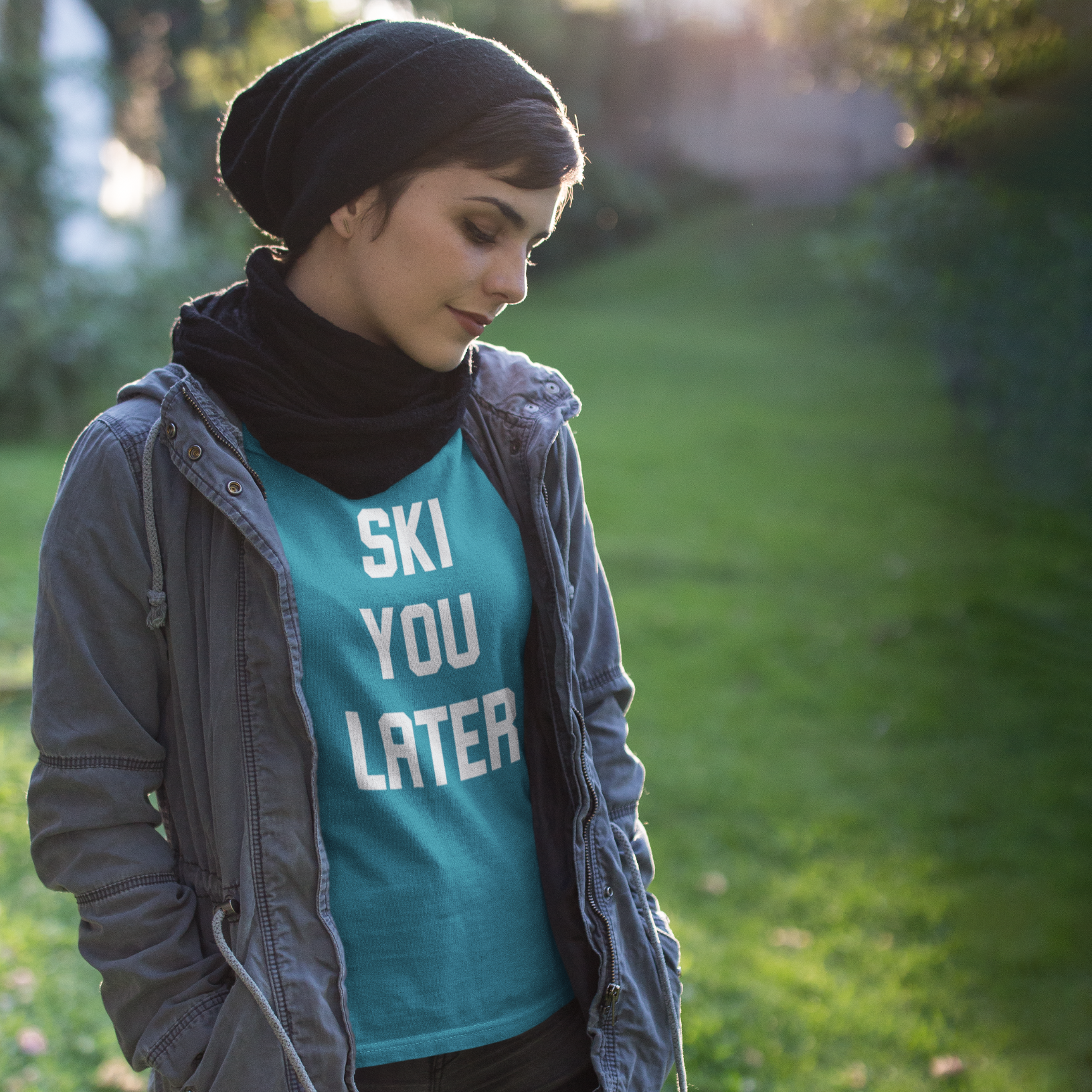 Women with aqua shirt, with 'Ski you later print' by KMLeon and black hat and scarf.